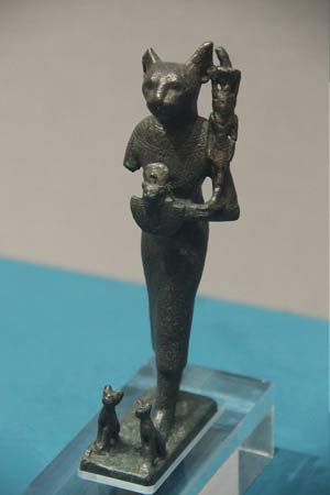 Estatua de bronce de la diosa Bastet con gatitos a sus pies.